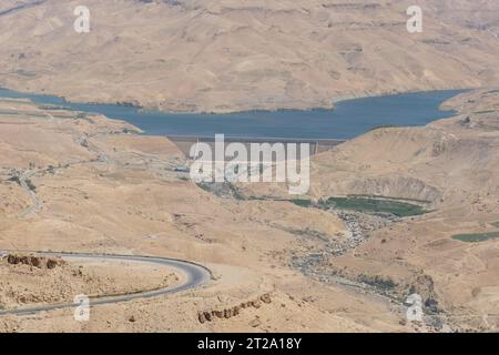 La diga di al Mujib vicino a Dhiban in Giordania contiene l'acqua del fiume Wadi al Mujib nel paesaggio desertico della Giordania preso nell'agosto 2023 Foto Stock