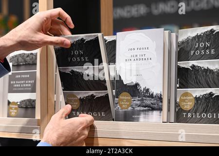 18 ottobre 2023, Assia, Francoforte sul meno: A Hand Reaches for a book of Norwegian Author Jon fosse at the Rowohlt Verlag stand at the Frankfurt Book Fair. Il paese ospite della più grande mostra di libri del mondo, che si tiene fino al 22 ottobre, è la Slovenia nel suo anniversario. Foto: Arne Dedert/dpa Foto Stock