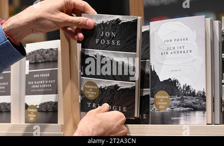 18 ottobre 2023, Assia, Francoforte sul meno: A Hand Reaches for a book of Norwegian Author Jon fosse at the Rowohlt Verlag stand at the Frankfurt Book Fair. Il paese ospite della più grande mostra di libri del mondo, che si tiene fino al 22 ottobre, è la Slovenia nel suo anniversario. Foto: Arne Dedert/dpa Foto Stock