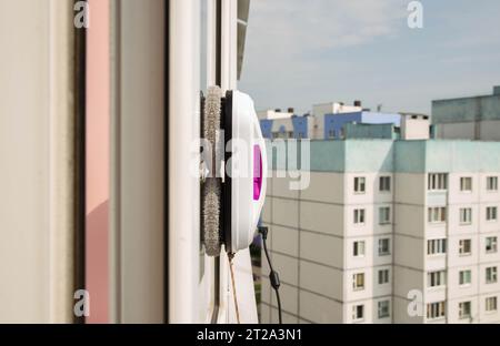 Un moderno robot aspirapolvere lavavetri lavavetri in un appartamento su un balcone. Vista dall'esterno dalla strada. Sicurezza dalle cadute dall'alto, automati Foto Stock