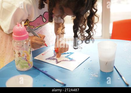 colorazione per bambini con sale e tecnica di verniciatura. ragazza a scuola che fa arte con il sale. Foto Stock