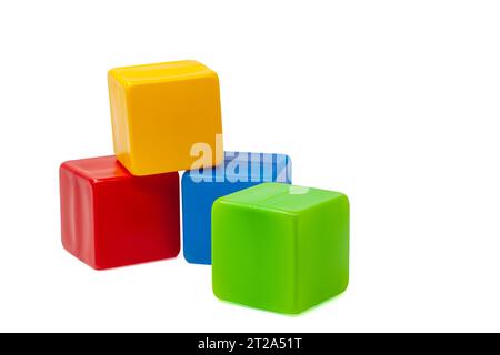 Cubi di plastica multicolore per giochi per bambini. Il cubo giallo si trova sopra il cubo rosso e blu, il cubo verde si trova accanto ad esso. Uno contro uno. Qualità elevata Foto Stock