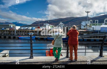 Un paio sulla riva di Ullapool, altopiani scozzesi a guardare le barche Foto Stock