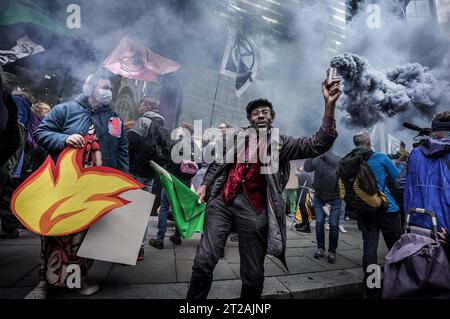 Londra, Regno Unito. 18 ottobre 2023. I soldi OutÕ gli attivisti per il cambiamento climatico della ribellione di estinzione (XR) marciano e protestano attraverso il distretto finanziario di cityÕs per chiedere la fine dei combustibili fossili e per Ôstop il flusso di oilÕ ÔOily. Crediti: Guy Corbishley/Alamy Live News Foto Stock