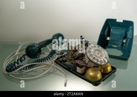 Un telefono fisso domestico con quadrante rotativo degli anni '1980 rotto, modello 706F.. La custodia del telefono è stata rimossa per rivelare il funzionamento interno. Foto Stock
