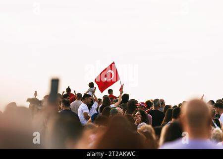 Smirne, Turchia - 9 settembre 2023: In mezzo al mare di persone esultanti in piazza Cumhuriyet per celebrare la liberazione di Smirne, spicca un individuo, p Foto Stock