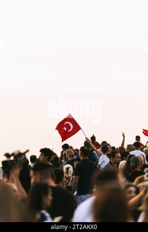 Smirne, Turchia - 9 settembre 2023: In mezzo al mare di persone esultanti in piazza Cumhuriyet per celebrare la liberazione di Smirne, spicca un individuo, p Foto Stock