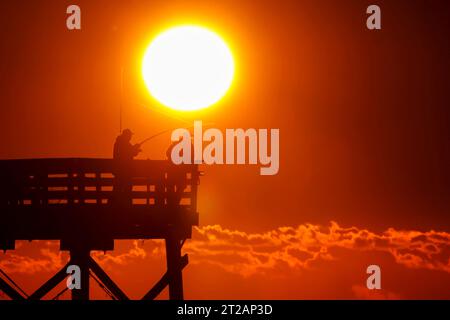 Isola di Palms, Stati Uniti. 17 ottobre 2023. Fisherman sagomato dall'alba tenta la fortuna dal molo Isle of Palms, il 17 ottobre 2023 a Isle of Palms, South Carolina. Crediti: Richard Ellis/Richard Ellis/Alamy Live News Foto Stock