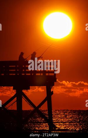 Isola di Palms, Stati Uniti. 17 ottobre 2023. Fisherman sagomato dall'alba tenta la fortuna dal molo Isle of Palms, il 17 ottobre 2023 a Isle of Palms, South Carolina. Crediti: Richard Ellis/Richard Ellis/Alamy Live News Foto Stock