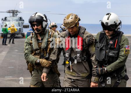 Artemis II Orion in corso Recovery test 10 (URT-10) - Day 4. I piloti di elicotteri navali dell'Helicopter Sea Combat Squadron (HSC) 23 "wildcard" scortano un pilota che funge da astronauta Artemis II sul ponte di volo delle navi durante una simulazione di recupero missione Artemis II come parte del test di recupero in corso 10 della NASA al largo della costa di San Diego. L'HSC-23 sarà responsabile del volo dell'equipaggio di Artemis II dalla navicella spaziale Orion alla nave di recupero dopo una missione di 10 giorni intorno alla Luna. Foto Stock