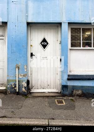 Porta in legno bianco e pareti dipinte di blu Foto Stock