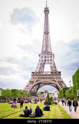 La gente si riunisce sul Champ de Mars vicino alla Torre Eiffel a Parigi, in Francia. Foto Stock