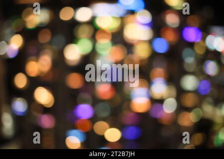 Le luci multicolori per le vacanze in città sfoggiano le palline bokeh sfocate del centro città attraverso l'obiettivo fisheye Foto Stock