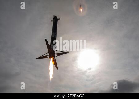 Un razzo Falcon Heavy atterra nella zona di atterraggio di SpaceX alla Cape Canaveral Space Force Station, Florida, pochi minuti dopo il lancio della missione Psyche della NASA dal Kennedy Space Center per studiare un asteroide ricco di metalli tra Marte e Giove, portando l'esperimento DSOC per le comunicazioni laser oltre la Luna. Foto Stock