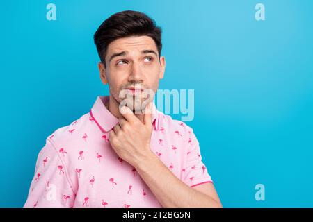 Ritratto di un giovane ragazzo attento al tatto del braccio sembra interessato spazio vuoto isolato su sfondo di colore blu Foto Stock