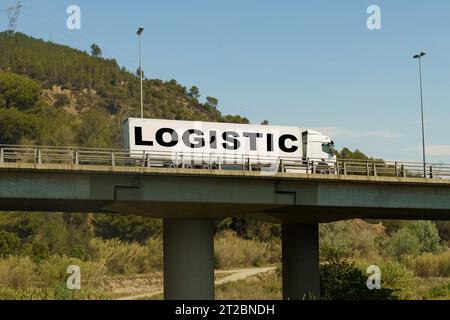 Un veicolo sta attraversando il ponte, con l'iscrizione sul rimorchio - Logistica. Concetto di logistica. Foto Stock