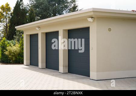 Vista esterna di un garage per tre auto con porte verdi alla menta. Garage per auto. Foto Stock