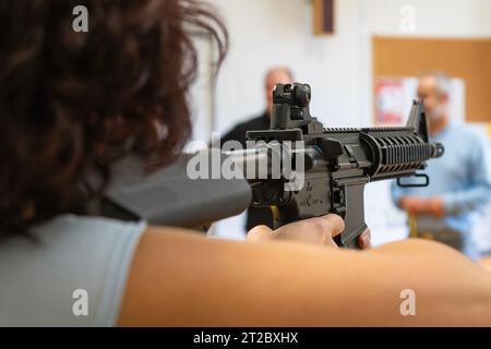 Una donna prende la mira con un fucile automatico M4 Foto Stock