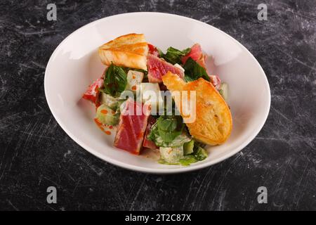 Insalata di tonno con foglie di lattuga, su sfondo scuro Foto Stock