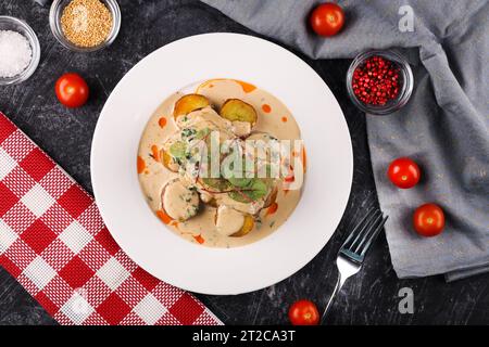 Delizioso filetto di merluzzo giallo o carbone, cucinato in una marinata piccante e servito con patate e salsa alla panna Foto Stock