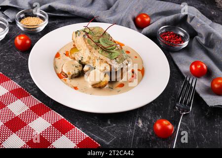 Delizioso filetto di merluzzo giallo o carbone, cucinato in una marinata piccante e servito con patate e salsa alla panna Foto Stock