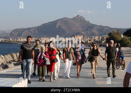 I pedoni passeggiano lungo la passeggiata sul lungomare di Palermo, in Sicilia Foto Stock