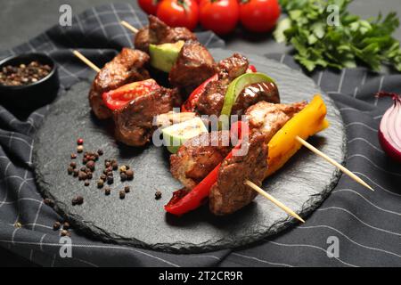 Deliziose shish kebab con verdure e spezie sul tavolo Foto Stock