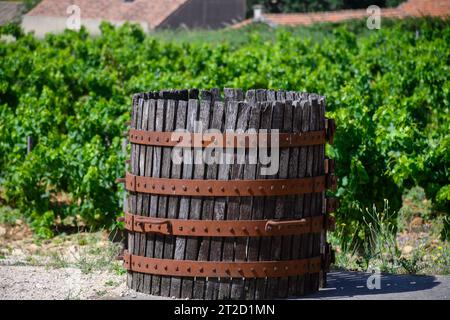 Vecchio torchio di vino nel villaggio francese di produzione del vino di Chateauneuf-du-Pape, con vigneti verdi su grandi ciottoli di galet e terreni arenari. Foto Stock