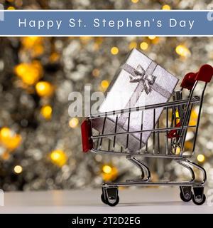 Composizione del testo dell'Happy st stephen's Day e confezione regalo nel carrello con decorazioni natalizie Foto Stock