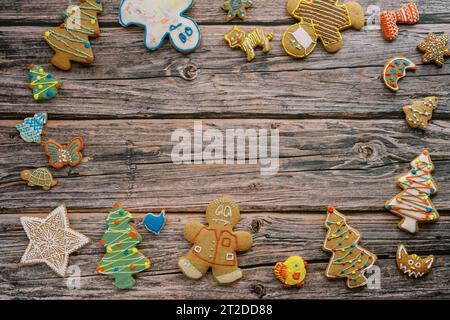 Gli ornamenti in biscotto smaltati si trovano su uno sfondo ruvido di legno scuro Foto Stock