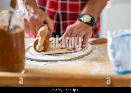 Dettaglio delle mani degli uomini che arrotolano l'impasto. Preparazione per la cottura della pasticceria tradizionale ceca. Piatti freschi fatti in casa Foto Stock