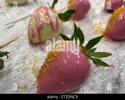 Splendida varietà di fragole fresche, colorate, gustose, dolci e succose, in cioccolato belga manomesso bianco e fondente al latte con decorazioni festive Foto Stock