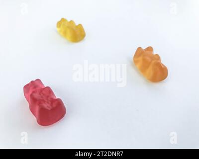 orsi gommosi su sfondo bianco opaco. orso rosso, giallo e arancione giacciono sul tavolo. dolci deliziosi, dolcetti per la gente. caramelle dei nostri prodotti Foto Stock