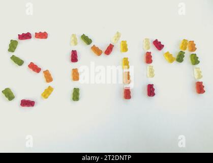 lettera di orsi gommosi multicolori. Lettere S e M a base di caramelle gelatinose. Parola commestibile SMM. commercializzazione di gomme. brillanti e dolci orsi gommosi. Foto Stock