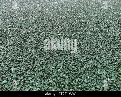 trama, sfondo. rivestimento per un campo sportivo in materiale gommato di colore verde smeraldo. superficie di scorrimento antiscivolo. Foto Stock