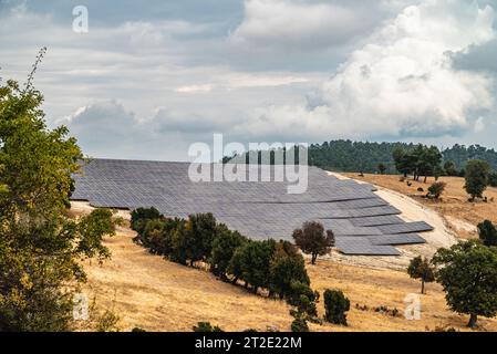 Campo di pannelli solari fotovoltaici costruiti sulle colline Foto Stock