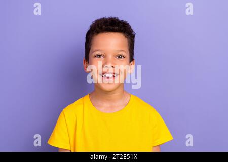 Foto di un allegro e funky ragazzo ispanico che indossa abiti gialli ha un buon umore isolato su sfondo di colore viola Foto Stock