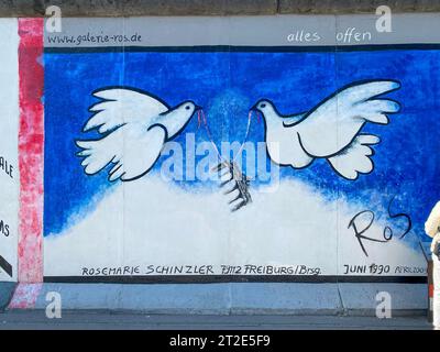 Le colombe della pace con la Porta di Brandeburgo dipinta su i resti del muro di Berlino, murale di Rosemarie Schinzler, East Side Gallery Foto Stock
