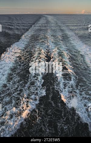 Vista dal ponte di poppa della nave da crociera sulla Norvegia vuota del Mare del Nord, onde d'acqua sveglia e schiuma bianca creata dalle eliche. Cielo all'alba mattutino. Foto Stock