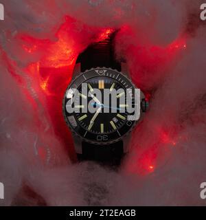 Un primo piano di un orologio da polso è costituito da nuvole rosse Foto Stock