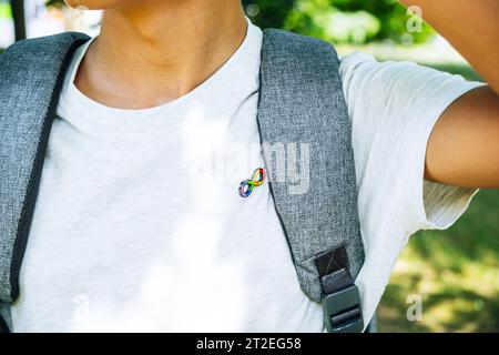 Bambino con zaino con segno simbolo dell'arcobaleno a infinito autismo. Giornata mondiale della consapevolezza dell'autismo, movimento per i diritti dell'autismo, neurodiversità, accettazione autistica Foto Stock