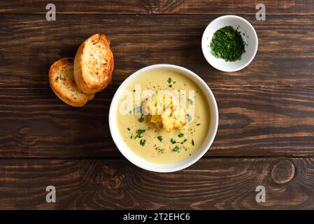 Zuppa dietetica di cavolfiore in ciotola su fondo di legno. Concetto di cibo vegetariano o sano. Vista dall'alto, base piatta Foto Stock