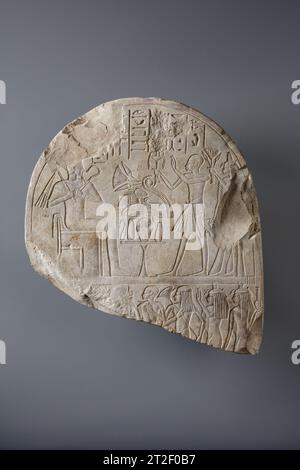 Parte superiore di una Stela New Kingdom ca. 1390–1352 a.C. questa stele raffigura il dio Osiride, a sinistra, che riceve offerte da un uomo che tiene un braciere nella mano destra, seguito da sua moglie, Henutnefret, che tiene un mazzo di gigli d'acqua. Il titolo dell'uomo, sdm ?Š (servo) è conservato nella colonna centrale del testo, ma il suo nome, nella colonna successiva a destra, è stato violato. Il geroglifico iniziale, una foglia di canna, è ancora visibile, quindi probabilmente era Amenofi (Amon è soddisfatto), o Amenemhat (Amon è il più importante). Entrambi i nomi, che includono riferimenti al dio Amon, sono stati attaccati du Foto Stock