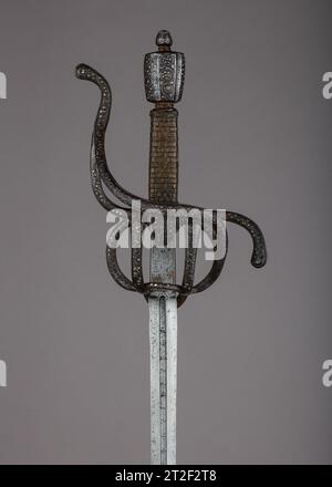 Rapier Hilt, italiano, forse Venezia; blade, spagnolo all'inizio del XVII secolo lo stupratore fu il principale braccio laterale civile per tutto il XVI e XVII secolo. Progettato per la recinzione di taglio e spinta di tecniche progressivamente complesse, lo stucco è caratterizzato da una lama a doppio taglio con punta acuta e da un'elaborata protezione per la mano. Le guardie, di solito di ferro o acciaio, erano soggette a una varietà di abbellimenti. Erano incise, cesellate, dorate, damascate e incrostate di oro e argento in linea con gli stili alla moda. Se non diversamente specificato, i materiali, attribuiscono Foto Stock