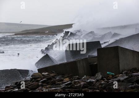 Orkney, Regno Unito. 19 ottobre 2023. METEO del Regno Unito: La tempesta Babet colpisce le Orcadi con venti di burrasca mentre il Met Office ha emesso un avvertimento meteorologico giallo per il nord-est della Scozia. I forti venti causano onde che si schiantano sulla A961 che attraversa una delle barriere Churchill sulle isole. Crediti: Peter Lopeman/Alamy Live News Foto Stock