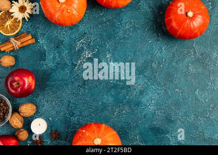 sfondo per il giorno del ringraziamento con zucche, noci e colorati oggetti autunnali su una superficie ruvida blu Foto Stock