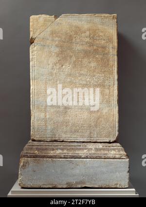 Statua in marmo con base incisa Roman ca. 160–170 d.C. si dice che la base sia stata trovata vicino a Roma, ma l'iscrizione è in greco. Registra la dedica di una statua in onore di Pompeia Agrippinilla, una sacerdotessa, che fu eretta dai compagni del culto bacchico a cui apparteneva. Sono elencati più di trecento nomi personali greci, insieme a circa settanta nomi romani; circa un terzo del totale sono quelli delle donne. I nomi sembrano rappresentare tutti i livelli della società, dal rango senatoriale agli schiavi, e sono ordinati in base allo status e alla funzione del culto. I loro titoli gi Foto Stock