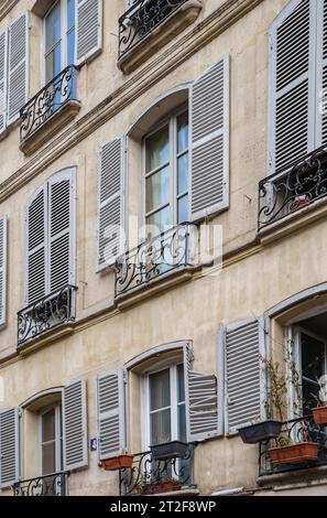 Vecchio edificio residenziale parigino con persiane in legno sulle finestre. PARIGI - 29 APRILE 2019 Foto Stock