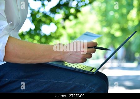 Contabile nel parco analizza i documenti azionari e le statistiche finanziarie. Concetto di commercio e documentazione. Primo piano Foto Stock