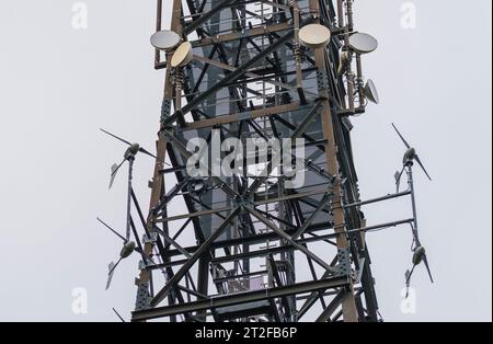 Bad Camberg, Germania. 20 ottobre 2023. Quattro delle otto turbine eoliche totali sono montate a un'altezza di 40 metri sotto il livello con l'apparecchiatura radio mobile sulla torre cellulare. L'operatore di torri cellulari Vantage Towers, insieme alla Start-up di energia eolica MOWEA con sede a Berlino, ha commissionato la prima torre cellulare con micro turbine eoliche integrate in Assia. L'energia rinnovabile generata dalle turbine viene utilizzata direttamente in loco per far funzionare il sistema, che può coprire fino al 100% della domanda di energia elettrica in condizioni di vento medio. Credito: Andreas Arnold/dpa/Alamy Live News Foto Stock